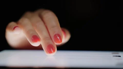 Woman scrolling website content on digital tablet screen in dark room close.. Stock Footage 334518254