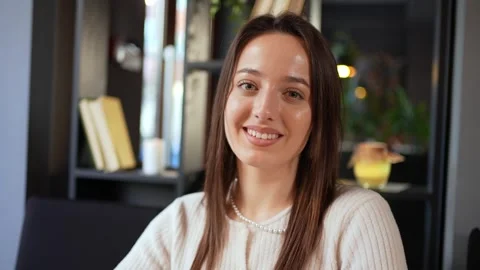 A woman is seated at a table, beaming at the Stock Footage 270220933
