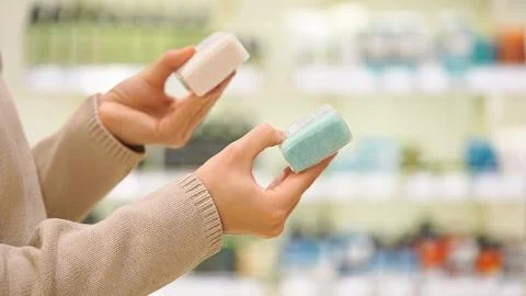 Woman selecting solid soap or shampoo bar in a beauty or eco store. 写真素材