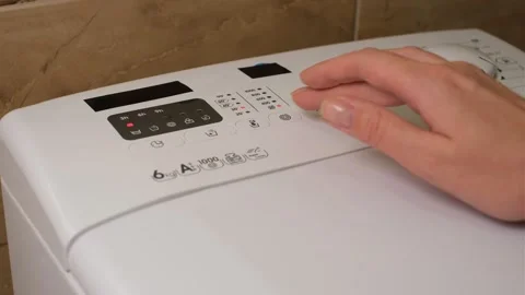 Woman selecting washing program on washing machine close-up of hands Video stock 321195890