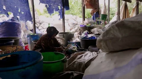 Woman separating plastic waste in plastic recycling factory. Processing of Plast Stock Footage 248089634