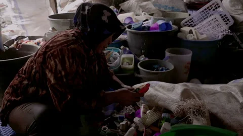 Woman separating plastic waste in plastic recycling factory. Processing of Plast Stock Footage 248092891