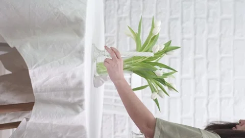 Woman served easter table, she is putting candles on table in white cosy living 動画素材 269749425