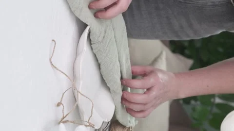 Woman served easter table, she is making bunny from napkin and egg on table in Stock Footage 269749485