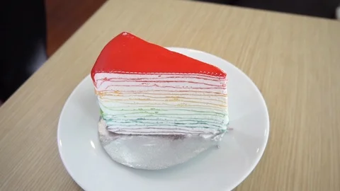 Woman  serving a rainbow crape cake on the table. Stock Footage 101275117