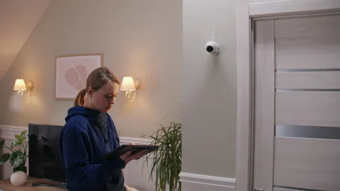 Woman sets up CCTV camera using tablet Stock Video Pond5