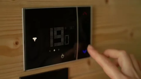 Woman sets the heating temperature to 16 degrees on the thermostat. Stock Footage 220198277
