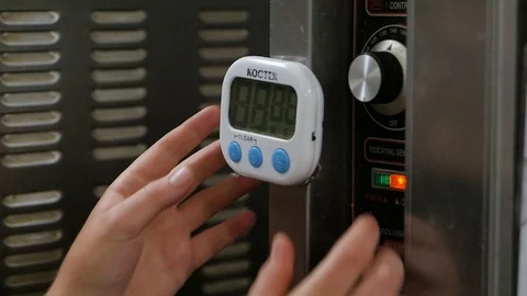 Woman sets small timer mounted on professional oven slow motion Stock-Footage 93378954