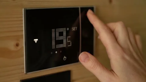 Woman sets the temperature of the heating Stock Footage 220198233