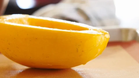 Woman Setting Down Half a Spaghetti Squash on a Roasting Pan Stock Footage 125110603