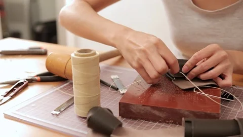 Woman sewing leather at home Stock Footage
