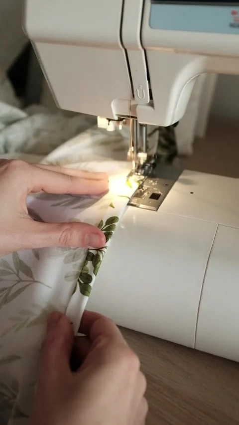 Woman sews bed lined or clothes on sewing machine. Manufacture of textile goods. Stock Footage 316920548