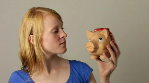 Woman shaking piggy bank Stock Footage