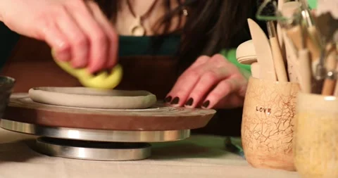 Woman shapes clay with yellow sponge 1 Видео 335047053