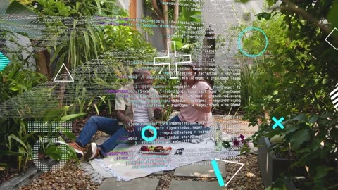 Woman sharing small object with man on blanket, causing tech code overlay Stock Footage 333671092