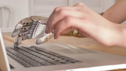 Woman with shiny bionic arm types on laptop at table closeup Stock Footage 150224458
