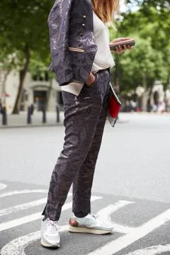 Woman in shiny patterned suit using smartphone in street Stock Photos