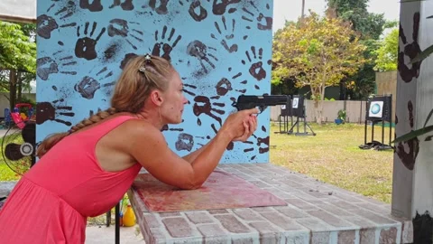 Woman shoots at shooting range with pneumatic gun. Outdoors entertainment for Stock Footage 247701181
