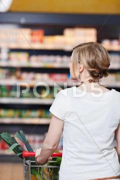 Woman with shopping cart at supermarket Stock Photos