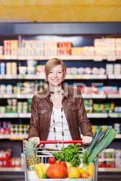 Woman with shopping cart in supermarket Stock Photos