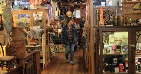 Woman shopping cluttered antique store Texas 4K Stock Footage 103380098