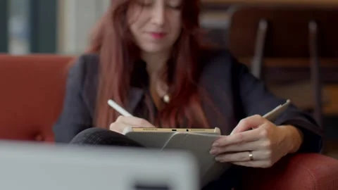 A woman showcases versatility using a tablet and notebook, balancing tasks Stock Footage 311206587