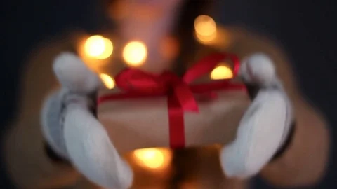 Woman showing Christmas gift in her hands. Female hands giving the gift in red. Stock Footage