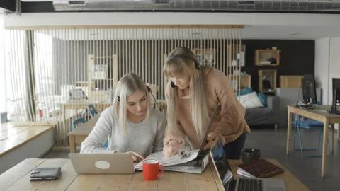 Woman is showing documents in folder another woman Stock Photos