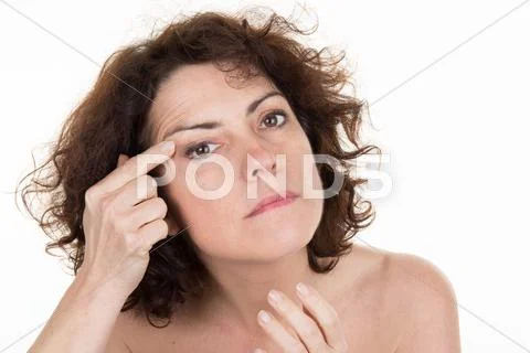 Woman showing by index finger the wrinkles on her forehead Stock Photos