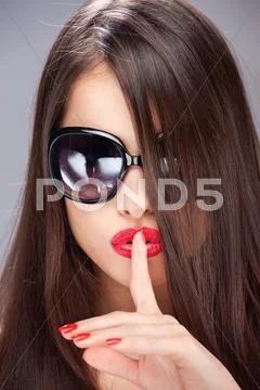 Woman showing the sign for silence with her index finger Stock Photos