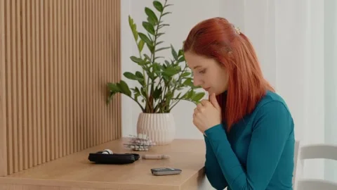 Woman shows glucometer reading high at 200 mg dL while sitting at home Stock Footage 334033053
