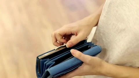 Woman shows her empty purses. Bankruptcy empty wallet clutches. The concept of Stock Footage 336450462