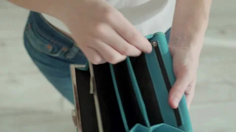 Woman shows her empty purses. Bankruptcy empty wallet clutches. The concept of Stock-Footage 336450480