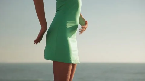 A woman shows how to align the down part of body  (on the beach). Stock Footage 42364295