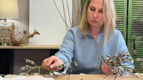A woman shows a master class on creating an Easter wreath of a nest of willow an Stock Footage 304946493