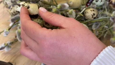 A woman shows a master class on creating an Easter wreath of a nest of willow an Video stock 304953859