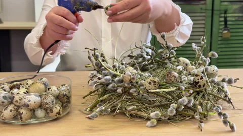 A woman shows a master class on creating an Easter wreath of a nest of willow an Stock Footage 304953976
