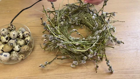 A woman shows a master class on creating an Easter wreath of a nest of willow an Vídeo Stock 304954067