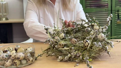 A woman shows a master class on creating an Easter wreath of a nest of willow an Stock Footage 304954172