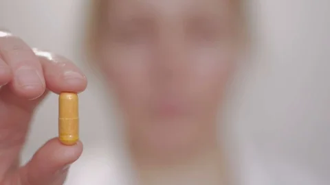 Woman shows a tablet while holding it with her fingers, then swallows it and Stock Footage 101074200