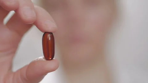 Woman shows a tablet while holding it with her fingers, then swallows it and Stock Footage 101074323