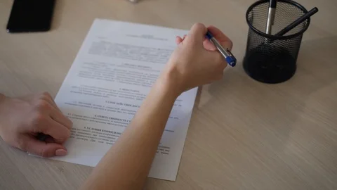 Woman signing documents on white table close up Stock Footage