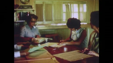 Woman signs paper and is handed a folder. Stock Footage