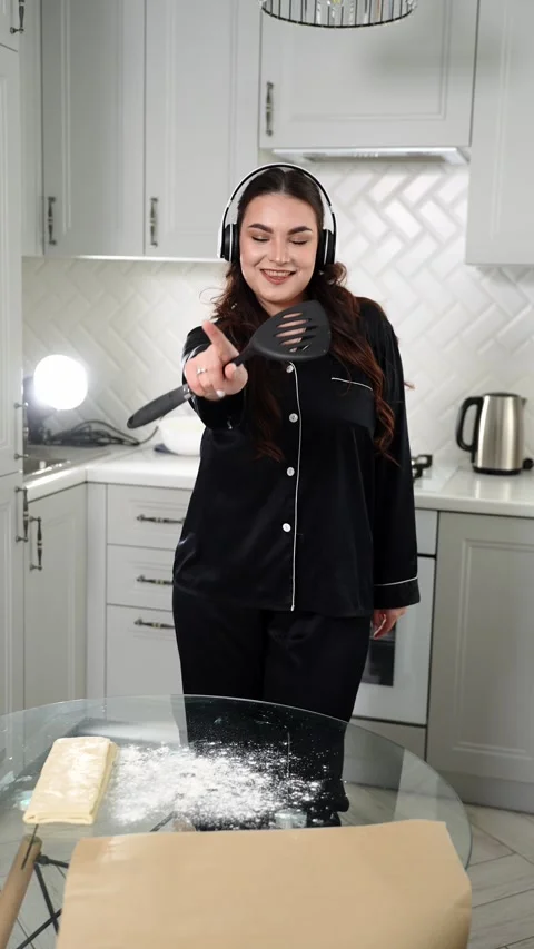 Woman singing and dancing in kitchen at home while cooking and baking. Happy Stock Footage 325613158