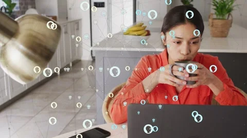 Woman sipping mug while glancing at laptop, causing animated node overlay 스톡 동영상 333818037