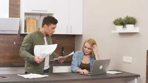 Woman sit crying while her husband explaining how to solve financial problems of Stock Footage 124096872