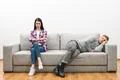 The woman sit near the sleeping man on the white wall background Photo