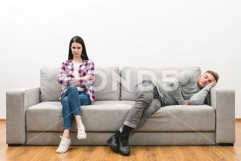 The woman sit near the sleeping man on the white wall background Stock Photos