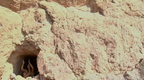 A woman sits and prays in a cave. Stock Footage