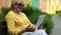 Woman sits on the bench and communicates via tablet PC HD Footage